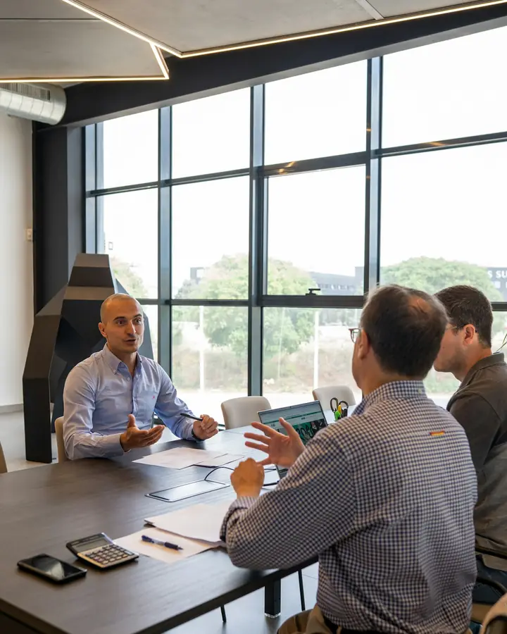 Operators meeting around a table in a sunlit office